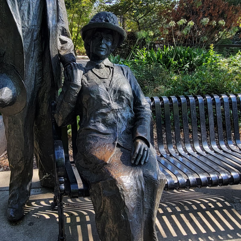 statue of woman sitting on bench